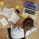 Businesswoman Working At Her Office Desk With Documents And Lapt